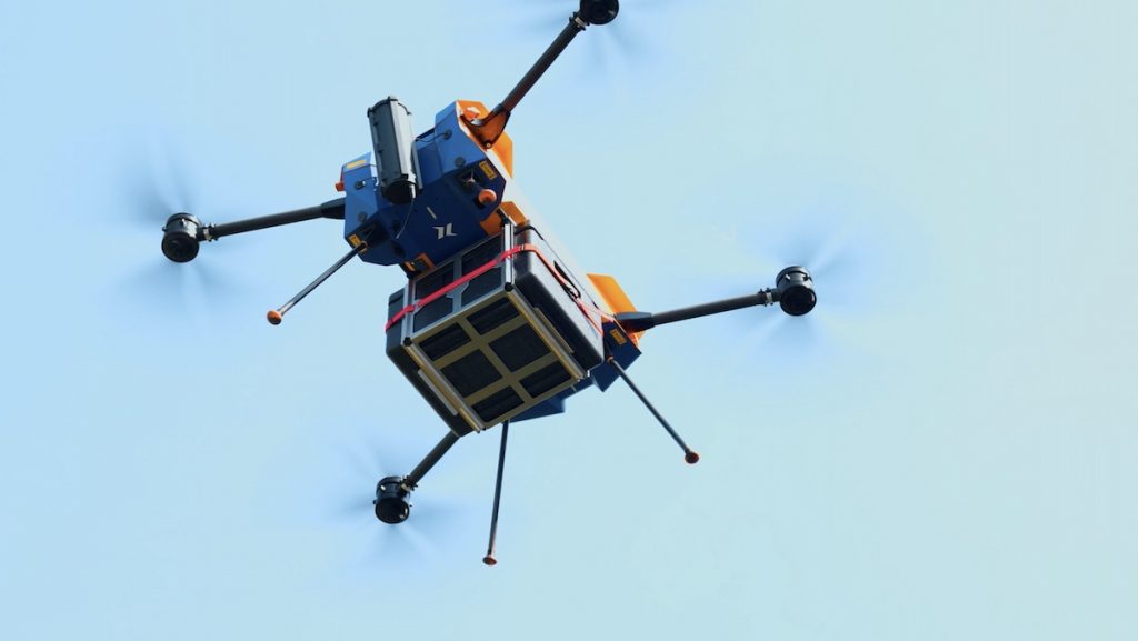 A cargo drone in flight with a transport box delivering lab samples